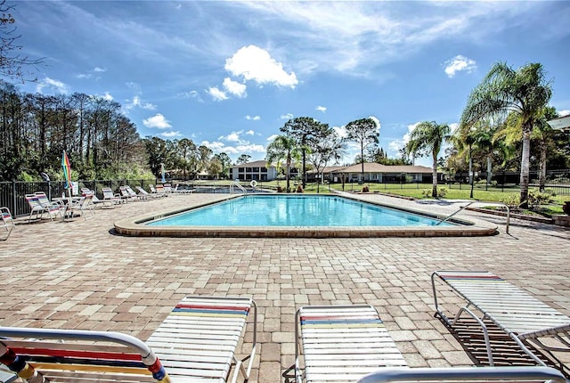 pool with a patio and fence