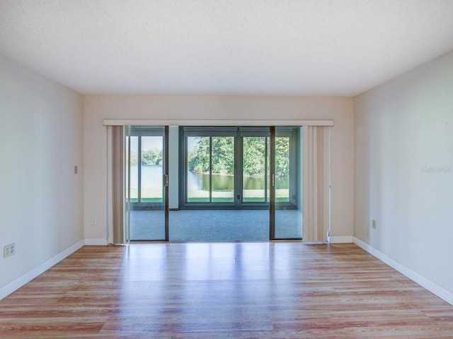 unfurnished room featuring baseboards and wood finished floors