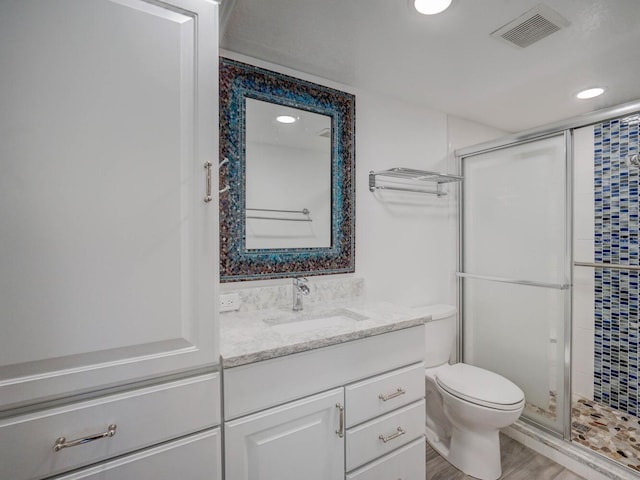 full bathroom with vanity, toilet, visible vents, and a stall shower