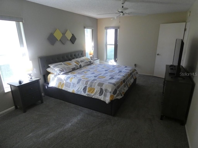 bedroom featuring a textured ceiling, dark carpet, and ceiling fan