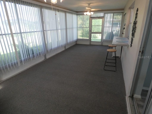 unfurnished sunroom with ceiling fan