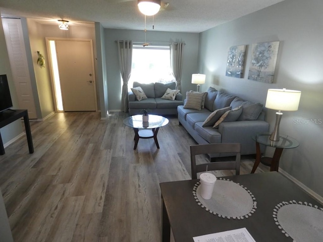 living room featuring a textured ceiling, hardwood / wood-style flooring, and ceiling fan