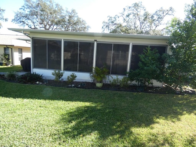 back of property with a yard and a sunroom