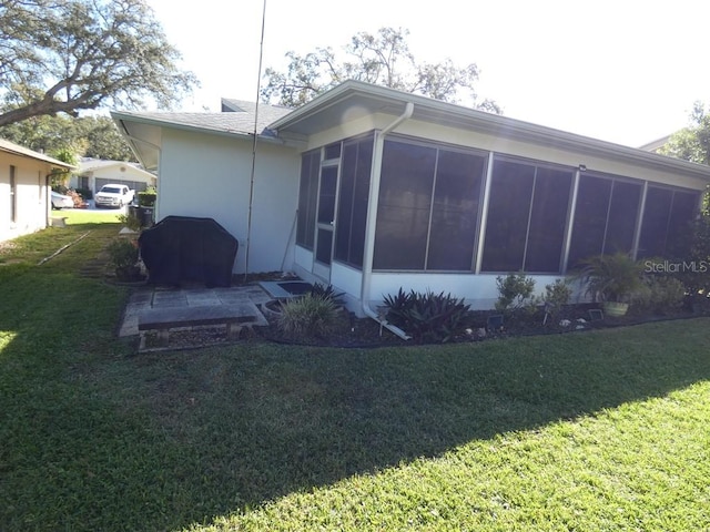 back of property featuring a yard and a sunroom