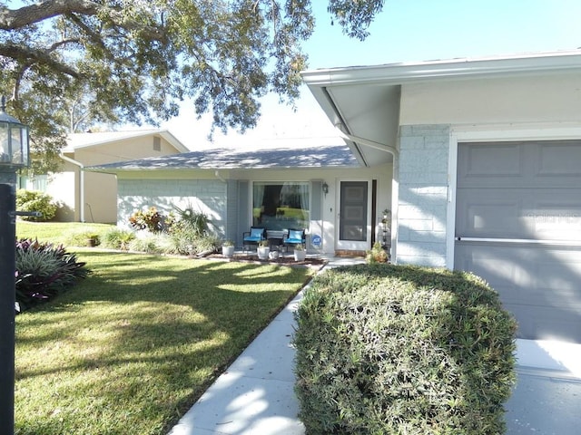 doorway to property featuring a garage and a lawn