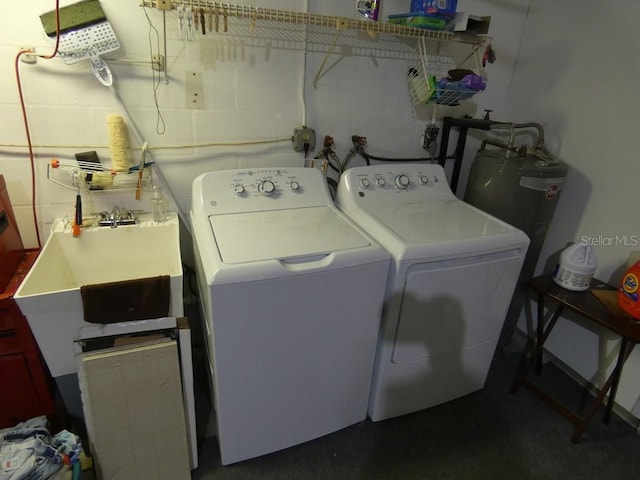 clothes washing area featuring electric water heater and separate washer and dryer