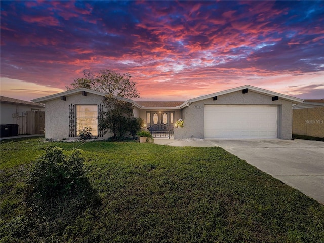 ranch-style home featuring a yard and a garage