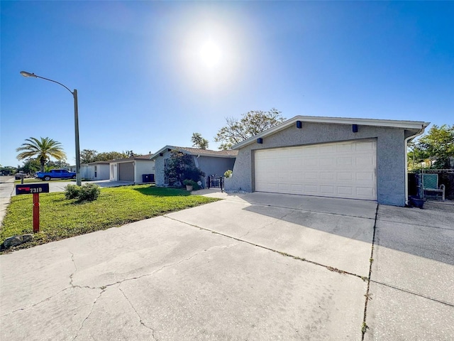 single story home featuring a garage and a front lawn