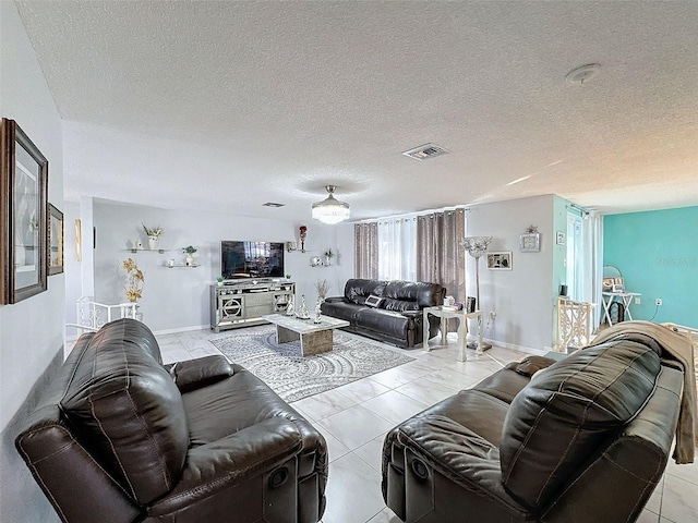 living room featuring a textured ceiling and light tile patterned floors