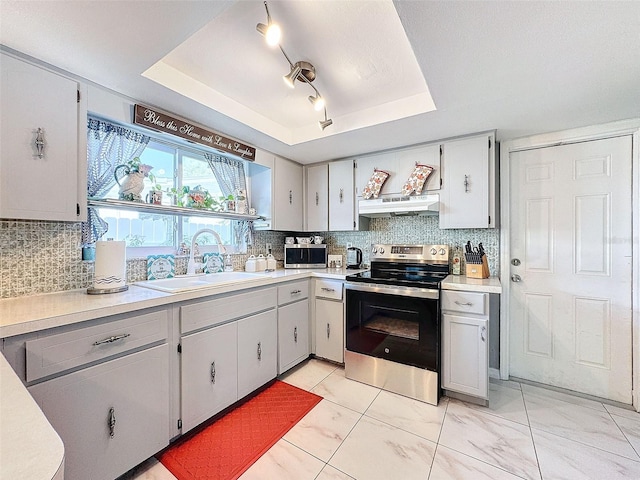 kitchen featuring sink, backsplash, a tray ceiling, and electric range