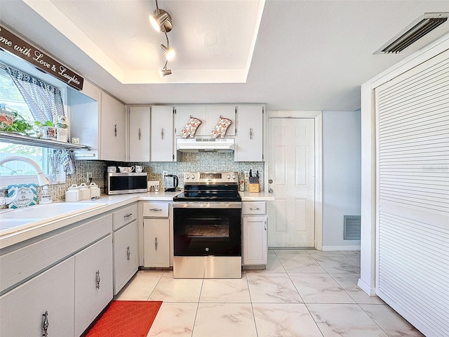 kitchen with sink, backsplash, a tray ceiling, white cabinetry, and stainless steel appliances