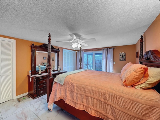 bedroom featuring ceiling fan, multiple closets, and a textured ceiling