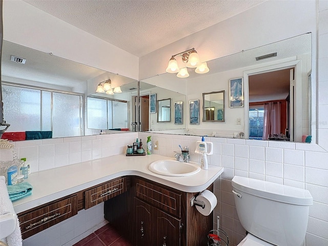 bathroom with decorative backsplash, toilet, vanity, tile walls, and a textured ceiling