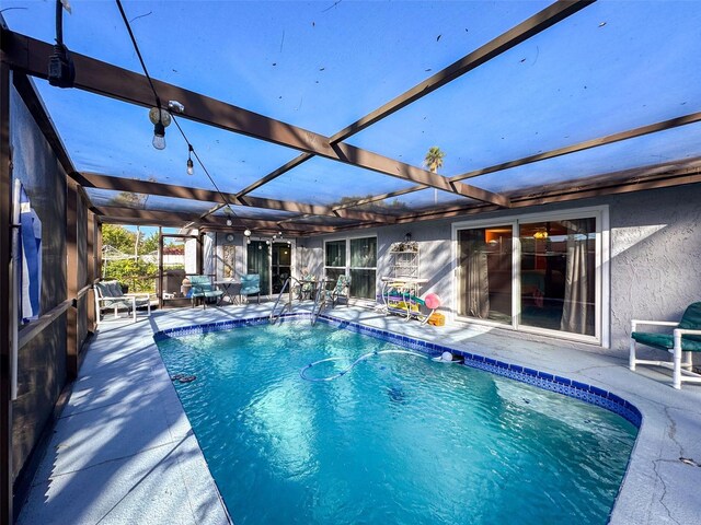 view of pool with a patio area and a lanai