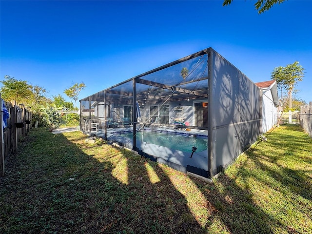 view of swimming pool featuring a lanai and a lawn