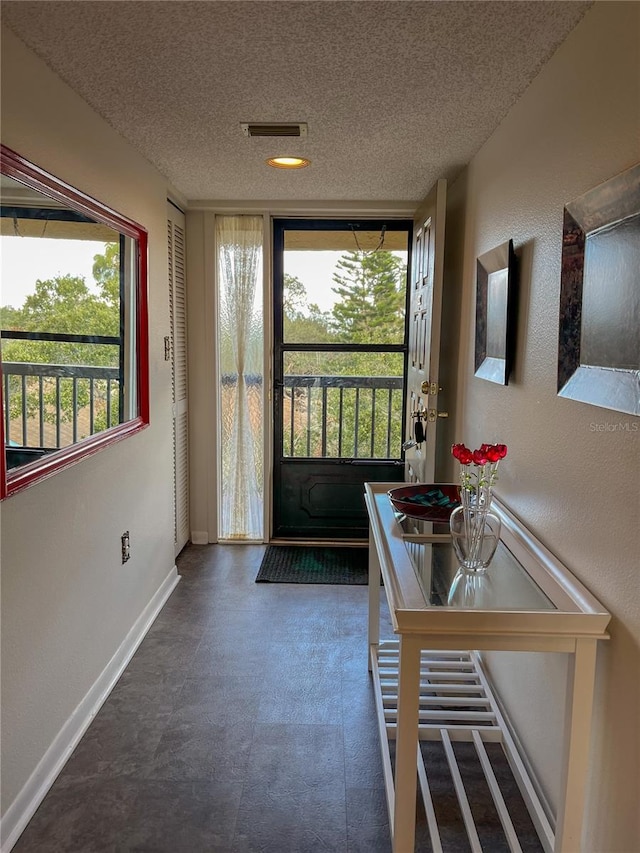 doorway with a textured ceiling