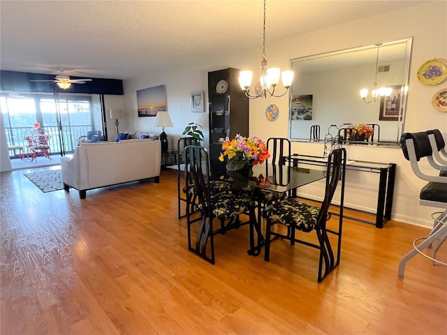 dining area featuring a textured ceiling, ceiling fan with notable chandelier, and hardwood / wood-style floors