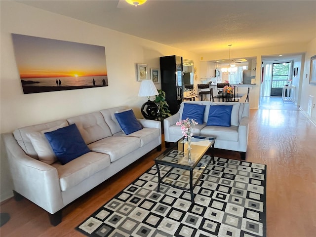 living room featuring a chandelier and wood-type flooring