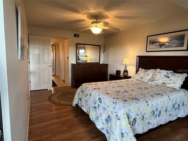 bedroom featuring a textured ceiling, dark hardwood / wood-style floors, and ceiling fan