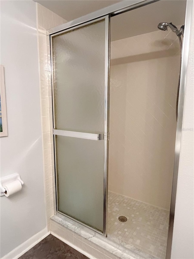 bathroom featuring a shower with shower door and tile patterned flooring