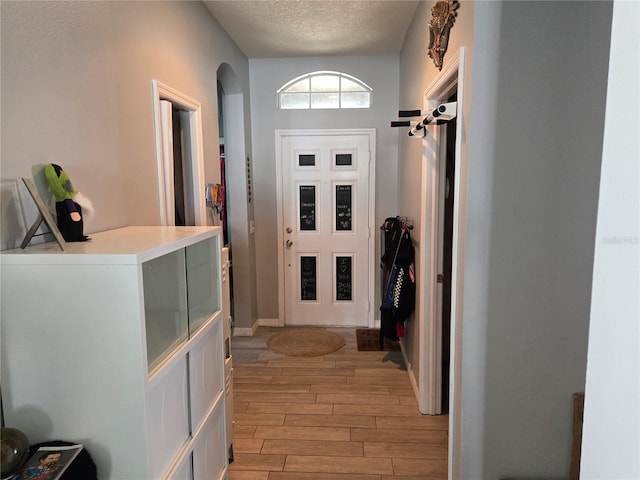 interior space with a textured ceiling and light hardwood / wood-style floors