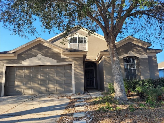 view of front of house with an attached garage, driveway, and stucco siding