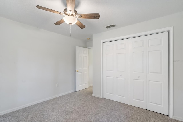 unfurnished bedroom featuring a closet, light carpet, and ceiling fan