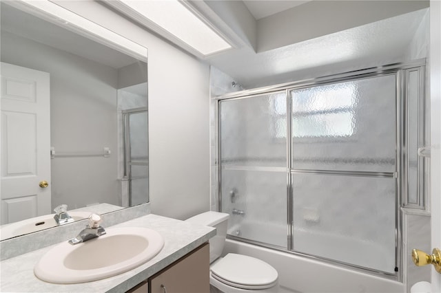 full bathroom featuring toilet, vanity, and enclosed tub / shower combo