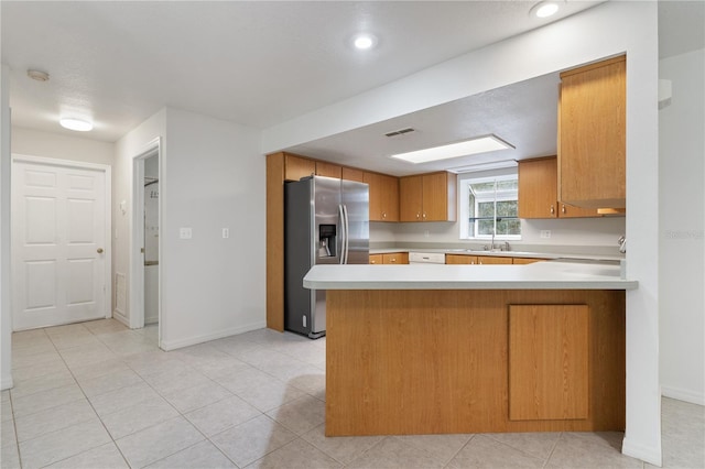 kitchen featuring light tile patterned flooring, stainless steel fridge with ice dispenser, sink, and kitchen peninsula