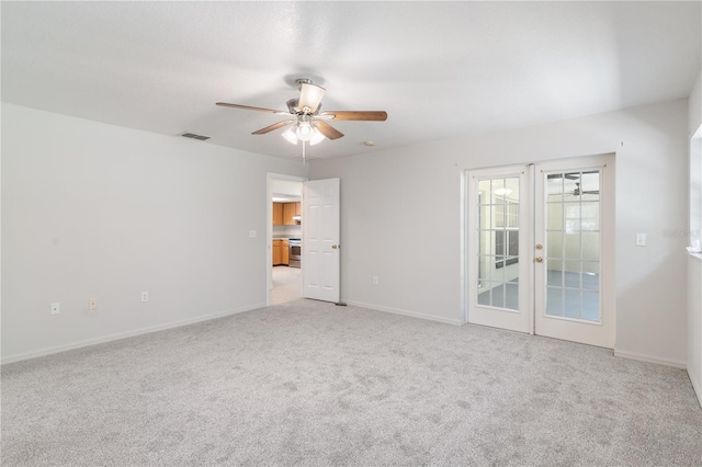 carpeted empty room with ceiling fan and french doors