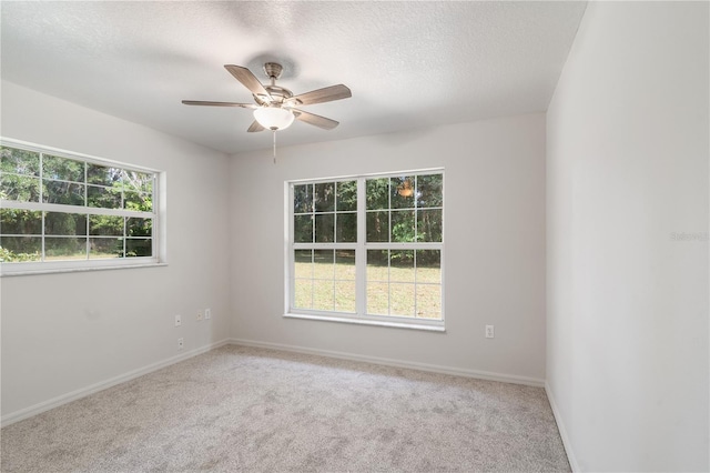 spare room featuring ceiling fan, a textured ceiling, and light carpet