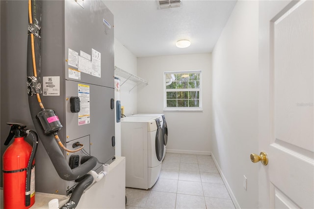 clothes washing area featuring separate washer and dryer and light tile patterned floors