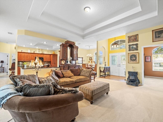 living area featuring a raised ceiling, visible vents, and french doors