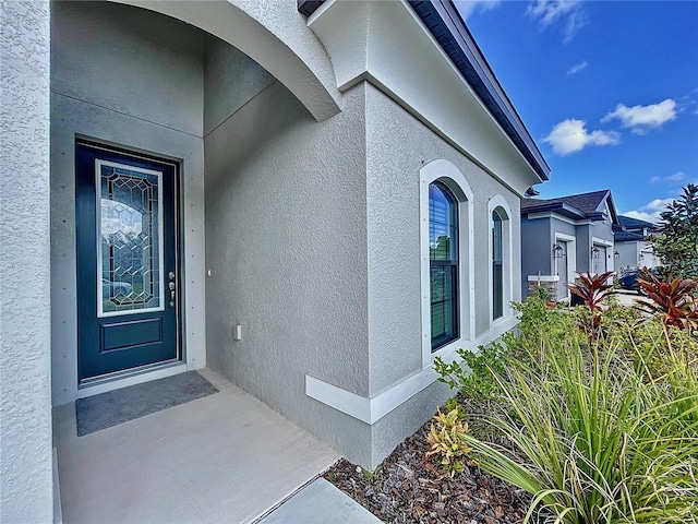 property entrance with stucco siding