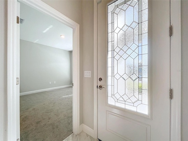 entryway featuring light carpet and baseboards