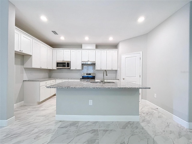 kitchen with marble finish floor, appliances with stainless steel finishes, white cabinetry, a sink, and an island with sink