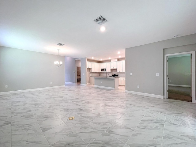 unfurnished living room featuring baseboards, marble finish floor, visible vents, and a notable chandelier