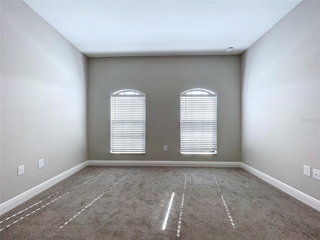 carpeted spare room with baseboards