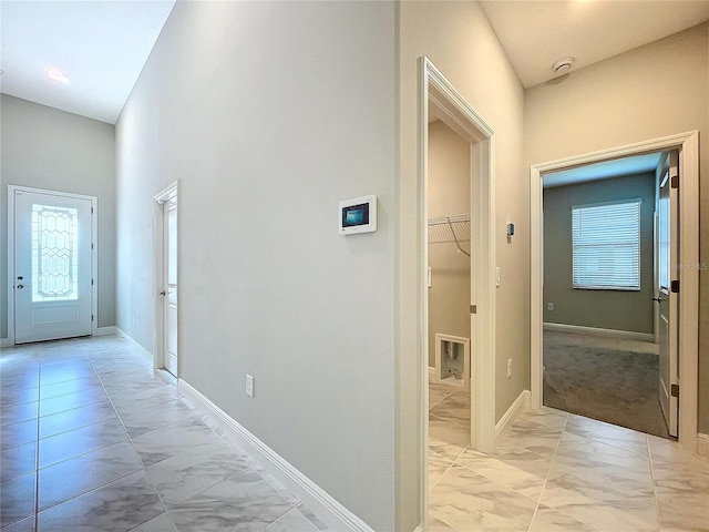 corridor with marble finish floor and baseboards