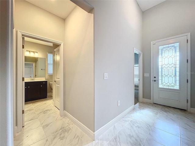 entrance foyer with marble finish floor and baseboards