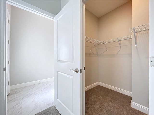 walk in closet with marble finish floor