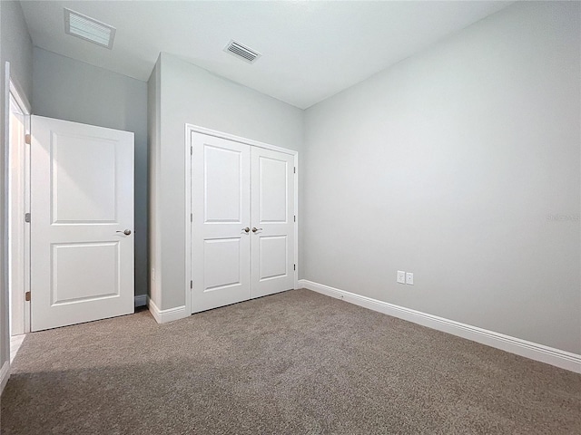 unfurnished bedroom with carpet floors, a closet, visible vents, and baseboards