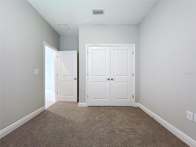 unfurnished bedroom featuring baseboards, a closet, visible vents, and carpet flooring