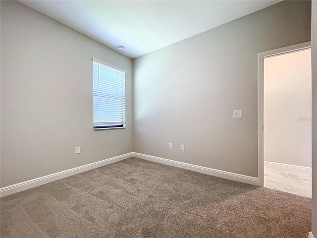 spare room with carpet and baseboards