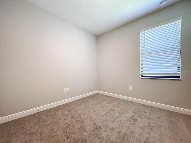 empty room featuring carpet floors and baseboards