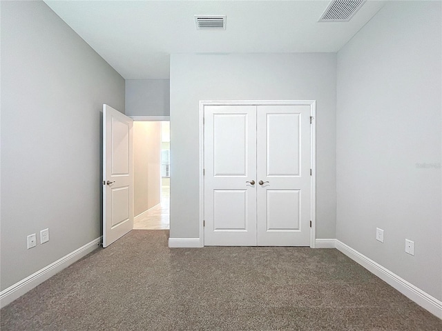 unfurnished bedroom featuring carpet, visible vents, and baseboards