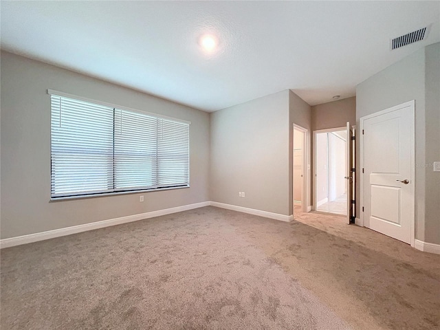 carpeted spare room with visible vents and baseboards