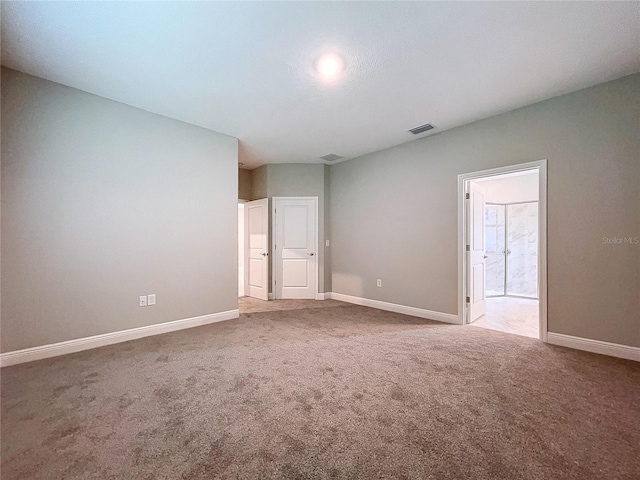 carpeted spare room featuring visible vents and baseboards