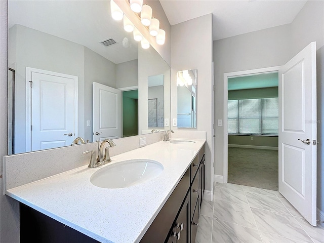 full bathroom featuring visible vents, a sink, baseboards, and double vanity