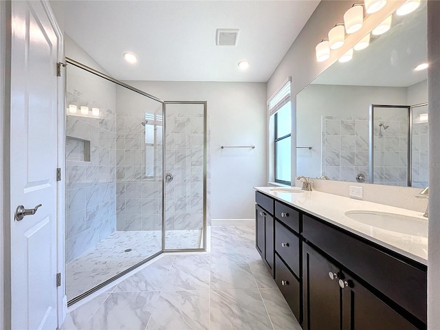 full bath with marble finish floor, visible vents, a sink, and walk in shower